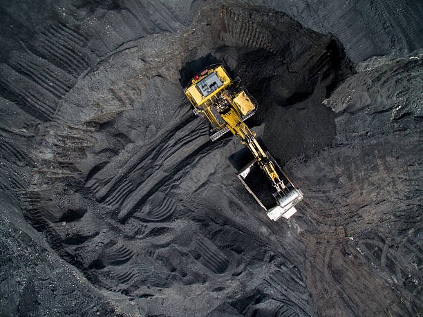 Top view of an excavator loading the truck with coal